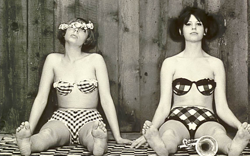A picture from the film Daisies of Jitka Cerhová and Ivana Karbanová wearing bikinis and sitting against a wall.